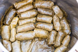 Steps of cooking dolma(tolma, sarma) from grape leaves stuffed with minced meat and rice. Dolma in the pot.