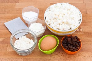 The baking ingredients for a syrniki on a wooden table closeup.