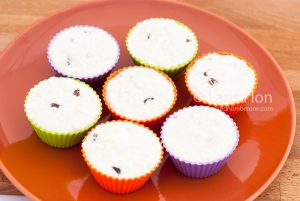 Cooking cheese and vanilla syrniki as cupcakes or muffins, in colored muffins cups closeup.