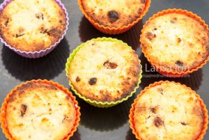 Cottage cheese syrniki, baked as cupcakes or muffins, in colored muffins cup on the oven-tray closeup.